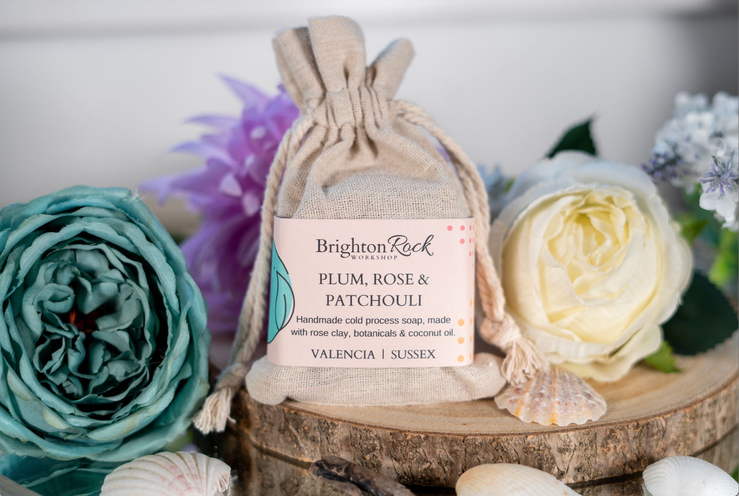 Plum, rose & patchouli scanted natural soap in cotton drawstring bag with Brighton Rock Workshop label. Handmade in Spain. Made with natural skin-loving ingredients. Olive oil, shea butter, coconut oil, cocoa butter, rose clay and botanical ingredients. eco friendly and sustainable